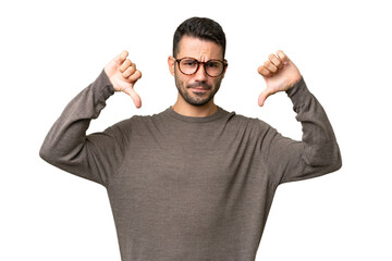 Fototapeta premium Young handsome caucasian man over isolated background showing thumb down with two hands