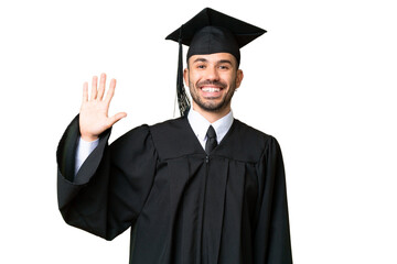 Young university graduate man over isolated chroma key background saluting with hand with happy expression