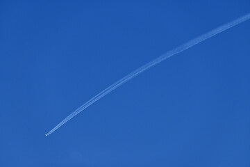 Fototapeta na wymiar Airplane flies fast to make contrails in the sky