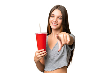 Teenager caucasian girl holding a soda over isolated background points finger at you with a confident expression