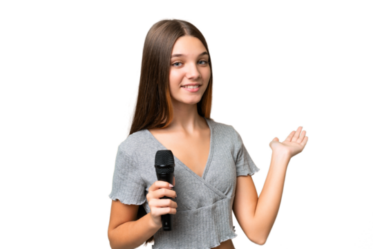 Teenager singer girl picking up a microphone over isolated background extending hands to the side for inviting to come