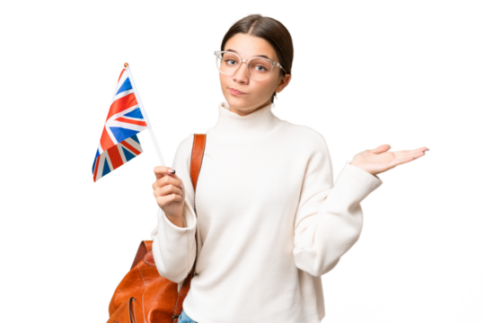 Teenager student caucasian girl holding an United Kingdom flag over isolated background having doubts while raising hands