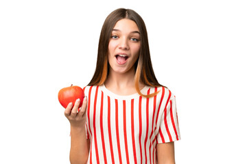 Teenager girl with an apple over isolated chroma key background with surprise and shocked facial...