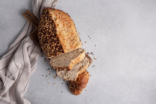 Organic homemade whole grain bread on wooden cutting board.