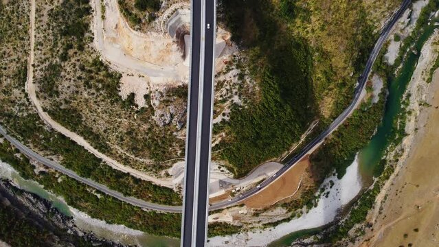 Top drone view of new modern expensive highway asphalt two lane road bridge over the Moraca river canyon in Montenegro, Europe. Motorway of reinforced concrete bridge in picturesque mountain valley.