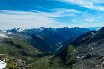 Fototapeta premium Panoramic view of majestic cloud covered mountain peaks of High Tauern, Carinthia Salzburg, Austria. Idyllic hiking trail in Goldberg group in wilderness of Austrian Alps. Tranquil mystical atmosphere