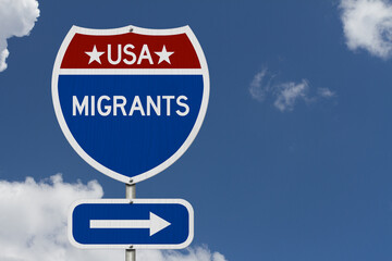 USA Migrants this way message on highway road sign