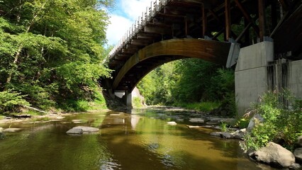 Arched bridge crossing gentle creek in countryside America New York State