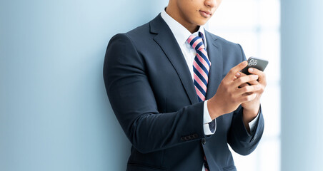 スマートフォンを使う若い外国人男性ビジネスマン