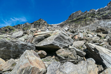 Hiking trail along unique rock strata formation with scenic view of majestic mountain peaks of High Tauern, Carinthia Salzburg, Austria. Extreme terrain in Goldberg group. Wilderness of Austrian Alps