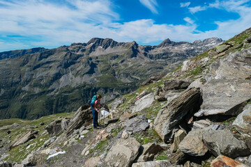 Fototapeta premium Hiker woman and unique rock formations with scenic view of mountain peak Weissseekopf in wild High Tauern, Carinthia Salzburg, Austria. Idyllic hiking trail Goldberg group. Wilderness of Austrian Alps