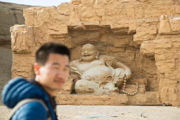 Silk Road Heritage City, Dunhuang City, Gansu Province - People standing in front of Buddha statues