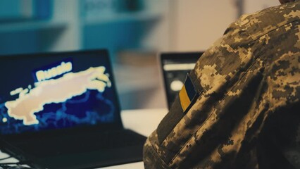 Ukrainian serviceman working in office, Russia map on computer, security data - Powered by Adobe