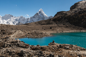 Alpine lake and Mount Ama Dablam on descent from Kongma La Pass during Everest Base Camp EBC or Three Passes trekking in Khumjung, Nepal. Highest mountains in the world.