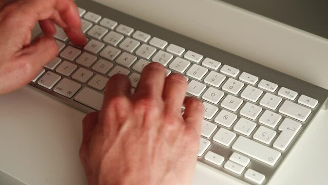 Manos de un hombre tecleando en un teclado
