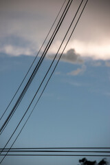 Fototapeta premium cable de electricidad sobre un cielo celeste con nubes