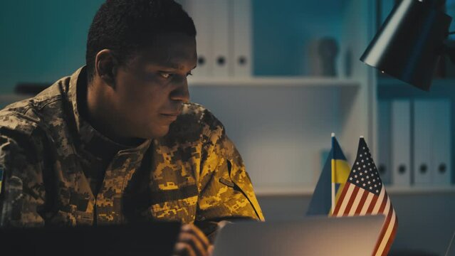 Ukrainian soldier analyzing intelligence data on computer, cooperation with USA