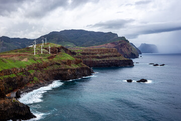 Rocky coast with wind farm from viewpoint - Ponta do Rosto - Madeira, Portugal