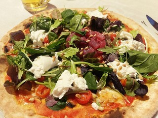 Italian pizza, pizza with raw tuna, tuna tartare, fresh lettuce leaves, pine nuts, burrata, fresh tomatoes