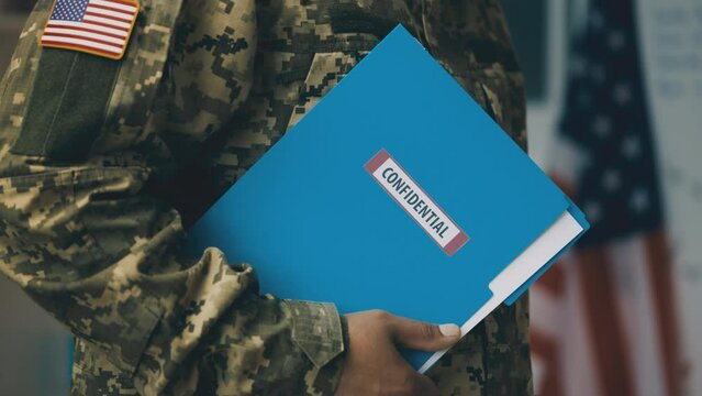American serviceman holding folder with confidential information, intelligence