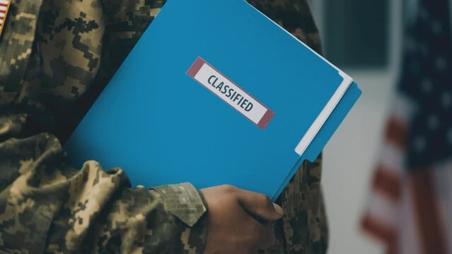 American serviceman holding folder with classified information, intelligence