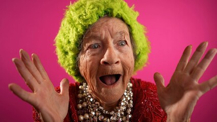 Funny elderly senior old woman with no teeth and wrinkled skin gives great idea gesture showing explosion of thinking posing isolated on pin background.