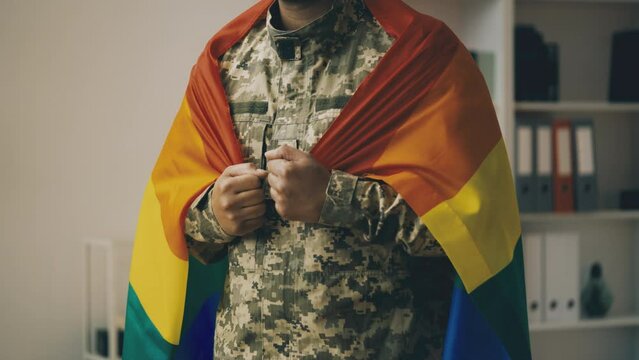 Military man wrapped in LGBT community rainbow flag, equal rights in army