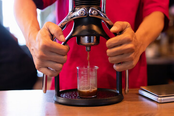 Fototapeta na wymiar Barista making espresso shot with classic espresso machine.