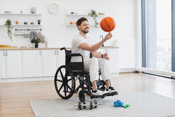 Cheerful bearded adult with mobility impairment dribbling ball in studio apartment on weekend....