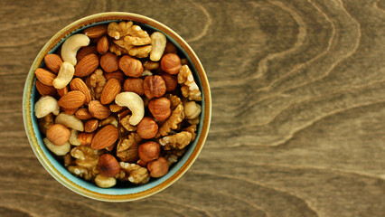 a plate of nuts. a nutritious and healthy snack. A mixture of walnuts, almonds, hazelnuts, cashews. Vegetarian food