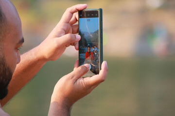 A person holding mobile phone for Photographpy