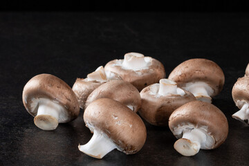 Organic brown mushroom on black background. Healthy food concept. Top view, close up.