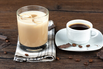 A cup of coffee and a glass of original Irish cream liqueur in a glass with ice.