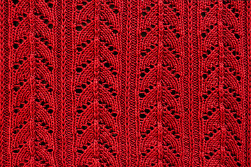 red background knitted openwork material with close-up pattern - obrazy, fototapety, plakaty