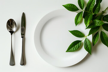 a white plate fork and spoon on table next to some gr - obrazy, fototapety, plakaty