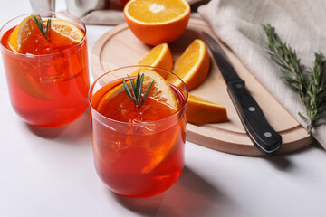 Aperol spritz cocktail, rosemary and orange slices on white wooden table
