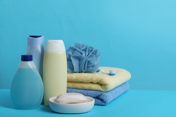 Baby cosmetic products, accessories and towels on light blue background. Space for text