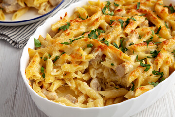 Homemade Cheesy Chicken Alfredo Pasta Bake in a Dish, side view. Close-up.