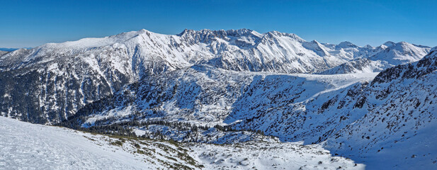 Majestic balkan mountains panoramic view. Rocky peaks ridge covered with snow in Bulgaria