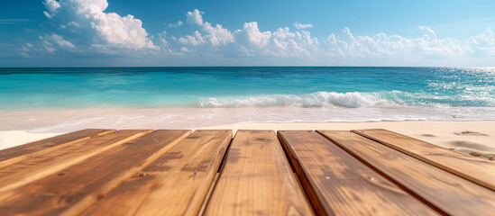 Empty wooden table or deck overlooking vast sandy beach and turquoise sea or ocean water. Copy space mockup 