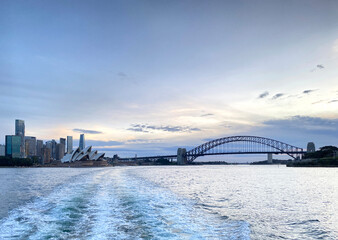 Sydney Harbour bridge, the Opera house and iconic skyscrapers at night. City harbour bridge silhouette at sunset. Largest steel arch bridge from the ocean at nightfall, Australia.