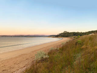 Sunrise on the beach. Dawn over the ocean. Morning rise at the beach. Tall grass, dunes and sand.