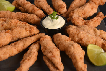 appetizer of fried chicken strips breaded with herb and lemon sauce