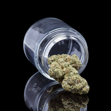 Cannabis in glass jar on black background