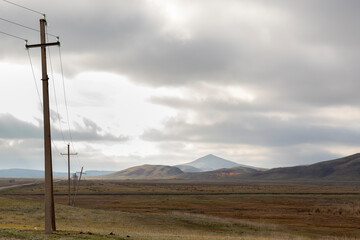 Fototapeta na wymiar poles for transmitting electricity along the road in the mountains 