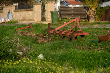 Fototapeta na wymiar old agricultural machinery lying near a house in the village 1
