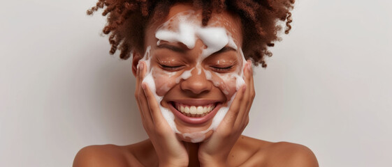 Joyful woman with a face full of soap suds, embracing skincare with a smile - obrazy, fototapety, plakaty