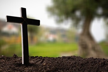 Praying wooden cross in soil outdoor