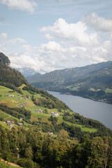 Fototapeta na wymiar Scenic view of green hills and a river in Amden, Switzerland