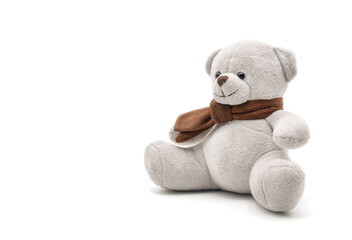 Gray teddy bear doll wearing a brown scarf sitting on white background